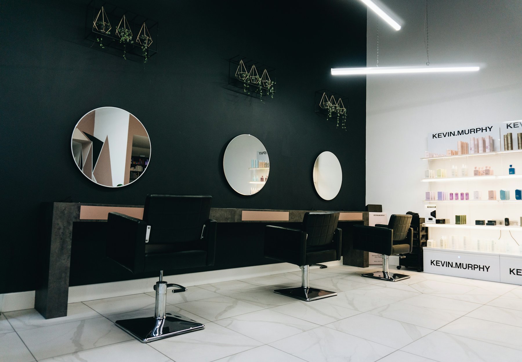 Cuts by Celal salon içi, yuvarlak aynalar ve kuaför koltukları